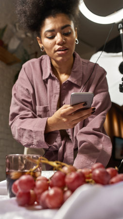 Girl take photo of drink and grapes on smartphone
