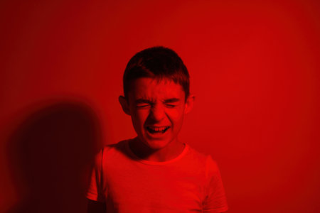 Irritated little boy with closed eyes screaming