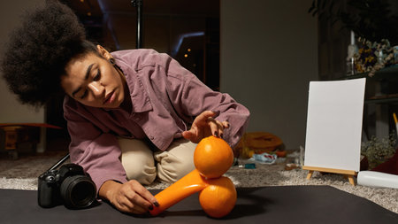 Photographer preparing tube with cream and oranges