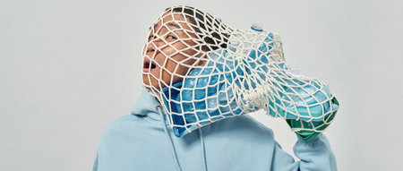 Tense man with knitted bag of garbage on his headの写真素材