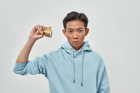 Young asian guy hold crumpled plastic cup