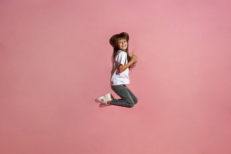 Side view of smiling european little girl jumping