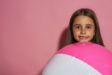 Cropped of smiling little girl with beach ballの写真素材