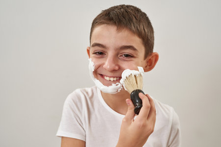 Partial of little boy smear shaving foam on faceの写真素材