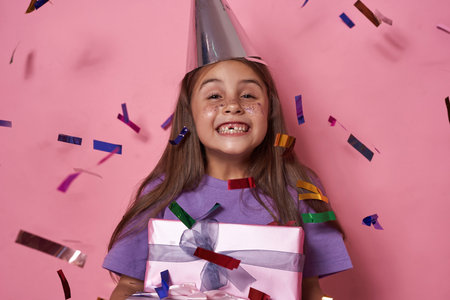 Joyful girl with gift boxes enjoy in fly confetti
