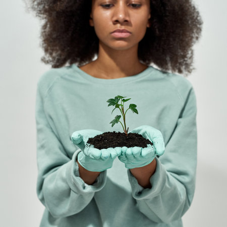 Ground with plant in hands of partial black girlの写真素材