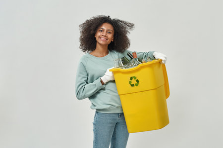 Young black girl hold dustbin with glass garbageの写真素材