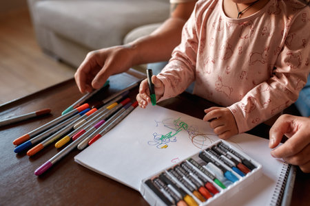 Partial of father and daughter draw in copybook