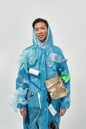 Front view of asian man wear raincoat with garbage
