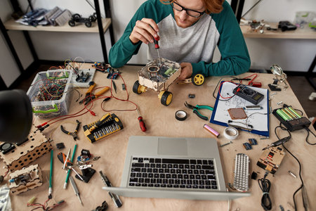 IT engineer fixing broken robot with screwdriver