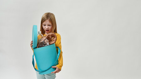 Displeased girl hold and look at garbage dustbin