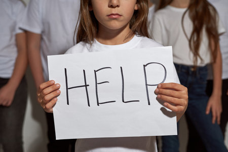 Girl hold Help placard and kids on demonstrationの写真素材