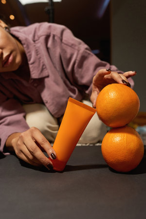 Girl preparing cream and oranges for taking photoの写真素材
