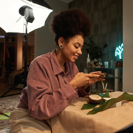 Woman take photo of rings, leaves, coconut and boxの写真素材