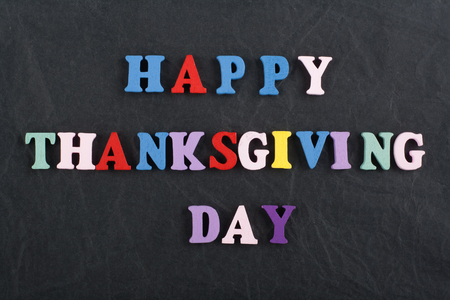 HAPPY THANKSGIVING DAY word on black board background composed from colorful abc alphabet block wooden letters, copy space for ad text. Learning english concept.の写真素材