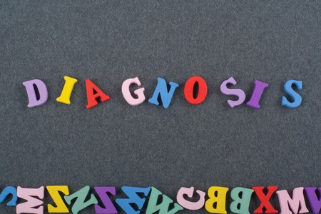 DIAGNOSIS word on black board background composed from colorful abc alphabet block wooden letters,...