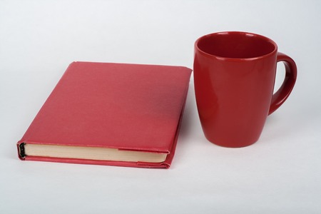 red book and cup on a white table. Copy space for text.の写真素材