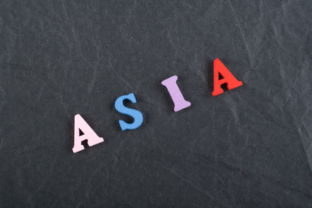 ASIA word on black board background composed from colorful abc alphabet block wooden letters, copy space for ad text. Learning english concept.の写真素材