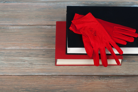 Book stacking. Open book, hardback books on wooden table and blue background. Back to school. Copy space for text. Knitted gloves.の写真素材