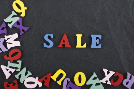 Sale word on black board background composed from colorful abc alphabet block wooden letters, copy space for ad text. Learning english concept.の写真素材