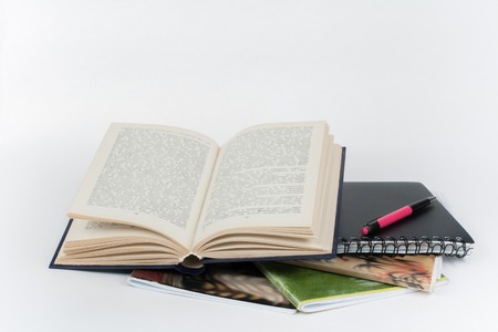 Open book, colorful notebook, pen on white table.の写真素材