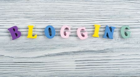 BLOGGING word on wooden background composed from colorful abc alphabet block wooden letters, copy space for ad text. Learning english concept.の写真素材