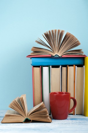 Open book, hardback books on wooden table and blue background. Back to school. Copy space for text.の写真素材