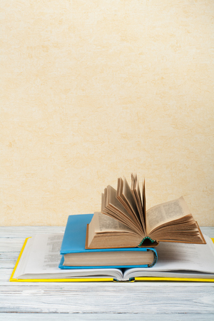 Open book, hardback colorful books on wooden table. Back to school. Copy space for text. Education business concept.の写真素材