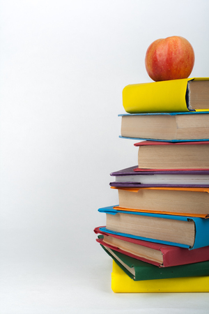 Stack of colorful real books, apple on white background, partial view. Back to school, Copy Space. Education .の写真素材