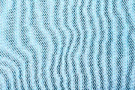 Sweater or scarf fabric texture large knitting. Knitted jersey background with a relief pattern. Wool hand- machine, handmade, blue.の写真素材