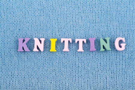 Knitting. Blue Knitted Fabric Texture. Word composed from ABC alphabet letters.