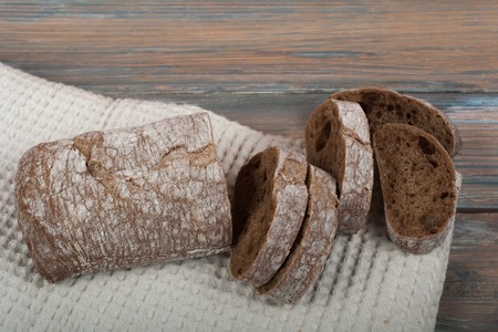 Many mixed breads and rolls of baked bread on wooden table background.の写真素材