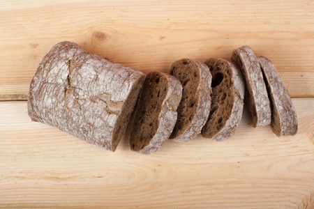 Many mixed breads and rolls of baked bread on wooden table background. Top view