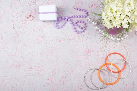 Workspace with computer, bouquet Hydrangeas, clipboard. Womens fashion accessories isolated on pink...