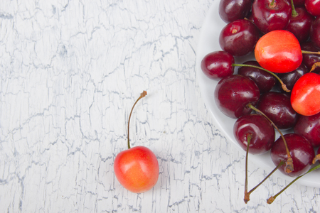 Various summer Fresh Cherry in a bowl on rustic wooden table. Antioxidants, detox diet, organic fruits.の写真素材
