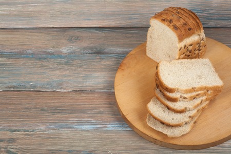 Many mixed breads and rolls of baked bread on wooden table background.の写真素材