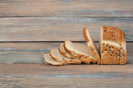 Many mixed breads and rolls of baked bread on wooden table background.の写真素材