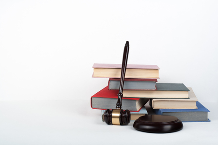 Law concept open book with wooden judges gavel on table in a courtroom or law enforcement office, white background. Copy space for text.の写真素材
