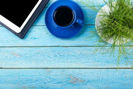 Blue office desk table with computer, pen and a cup of coffee, lot of things. Top view with copy space.の写真素材