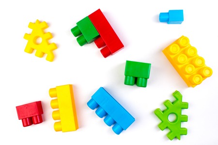 Lot of colorful rainbow toy bricks background. Educational toy for children Isolated on white...