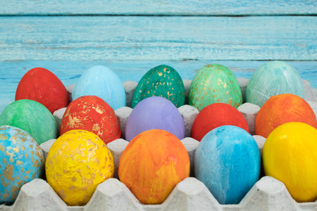 Happy Easter card. Colorful shiny easter eggs on wooden background. Copy space for text.の写真素材