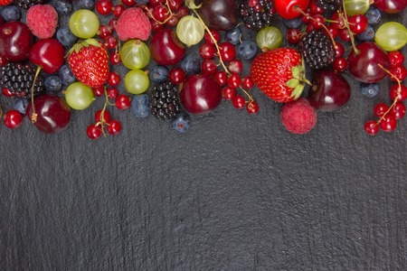 Various summer Fresh berries in a bowl on rustic wooden table. Antioxidants, detox diet, organic fruits. Top viewの写真素材