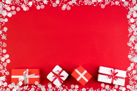 Gift boxes and colorful present for christmas on red background. Top view with copy space.