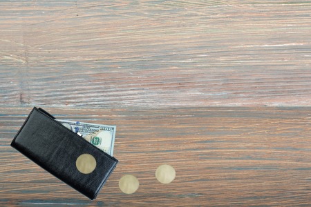 leather wallet with dollar bill on wooden table. Top view.の写真素材