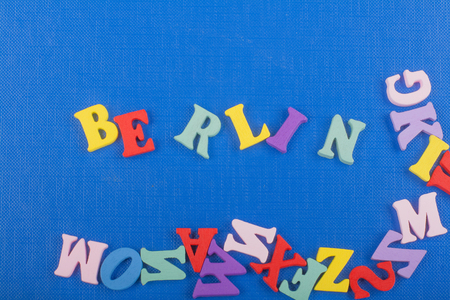 BERLIN word on blue background composed from colorful abc alphabet block wooden letters, copy space for ad text. Learning english concept.の写真素材