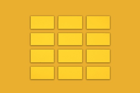 Mockup of horizontal gold business cards stacks arranged in rows at gold background.の写真素材