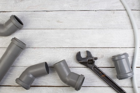 Fittings, pipe, valves, plastic pipe for water, water hose, adjustable wrench on the wooden...
