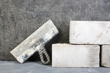 silicate bricks, putty knife on the gray concrete background. Copy space. Top view.の写真素材