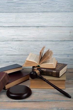 Law concept - Open law book with a wooden judges gavel on table in a courtroom or law enforcement office isolated on white background. Copy space for text.の写真素材