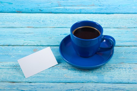Blank business cards, blue cup on the wooden table. Office desk tabl. Template for ID. Top view. A cup of coffee.の写真素材